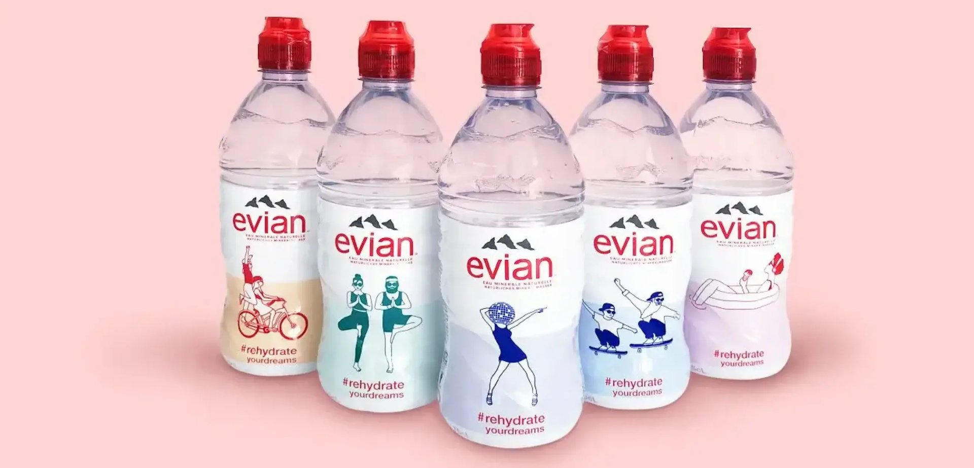 Fünf Evian-Flaschen stehen vor einem rosa Hintergrund.