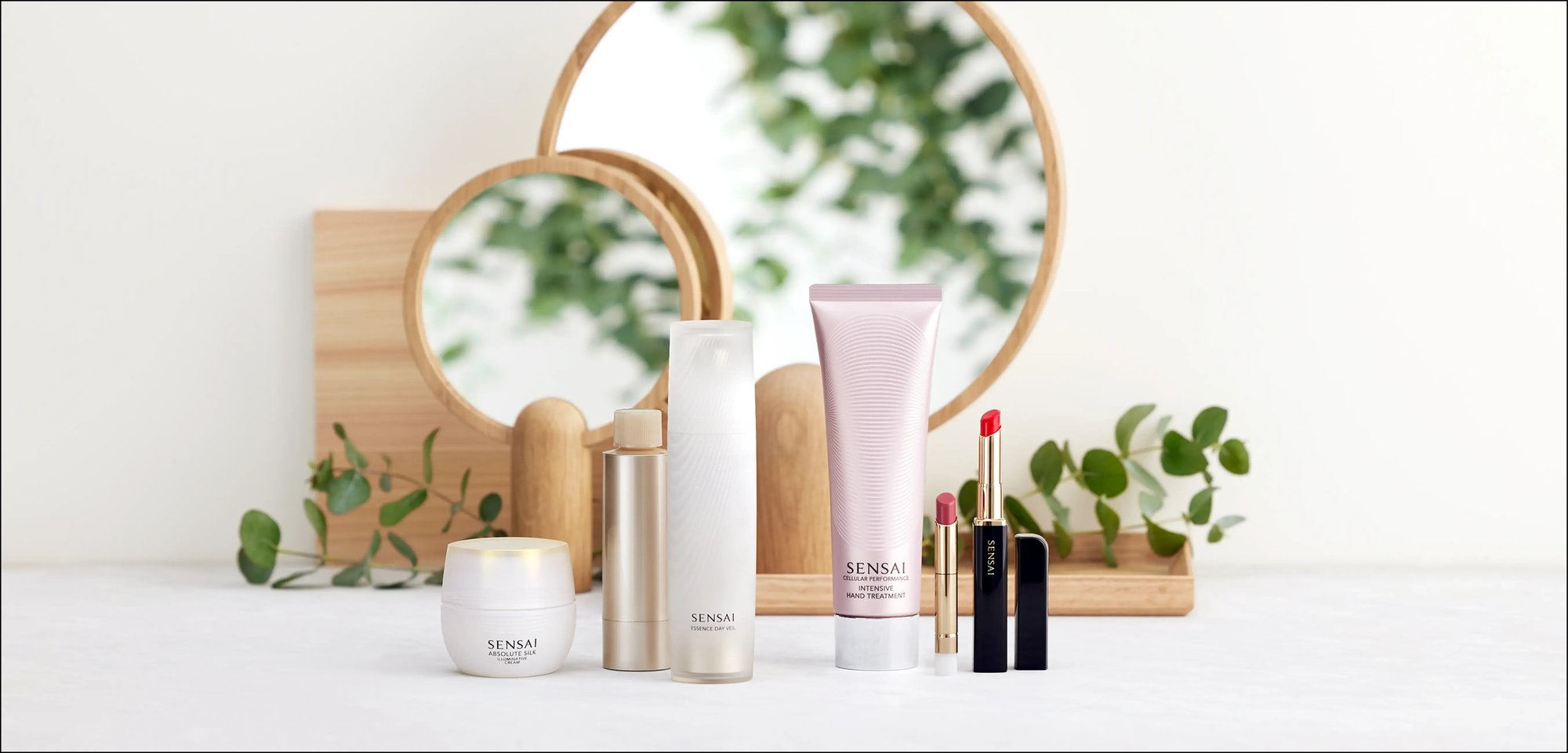 Beauty-Produkte von Sensai stehen vor Spiegeln.