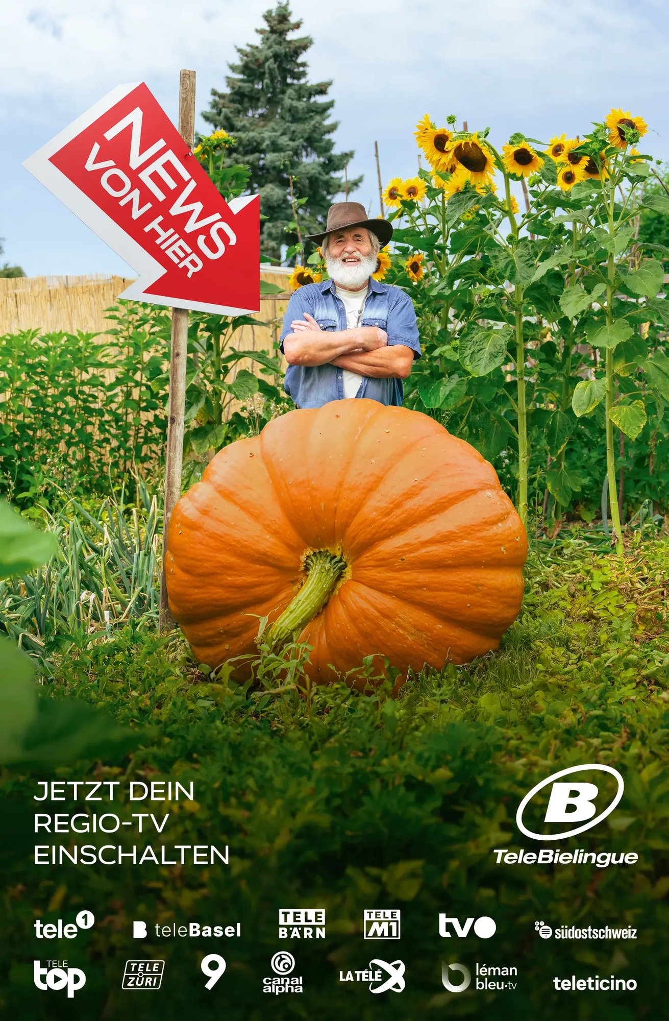 Ein Mann steht in einem Schrebergarten hinter einem grossen Kürbis. Ein Schild in Form eines Pfeils auf welchem steht "News von hier" zeigt auf den Kürbis.